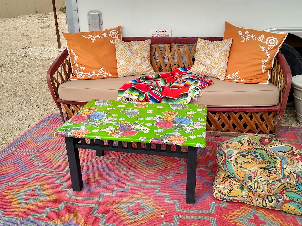 A colorful table and bench in the middle of an outdoor area.