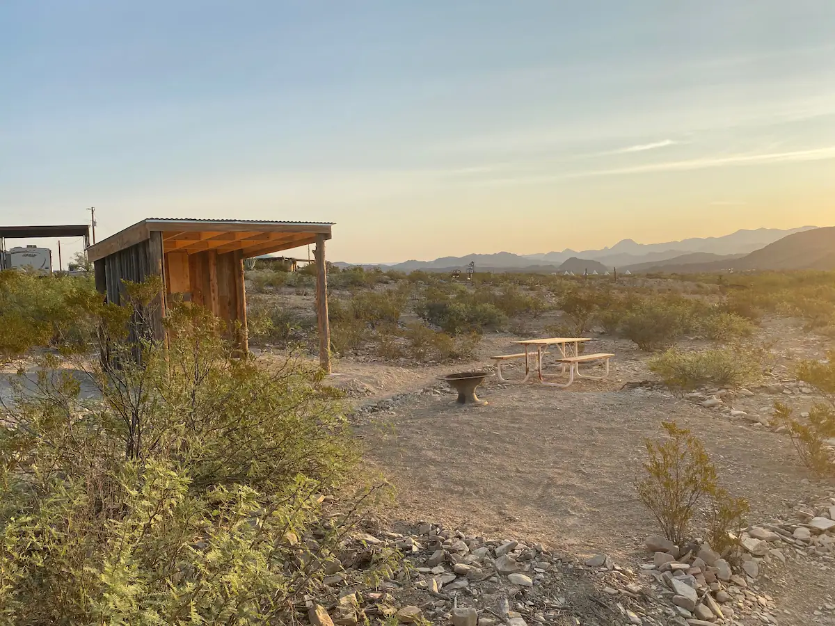 A hut in the middle of nowhere with a picnic table.