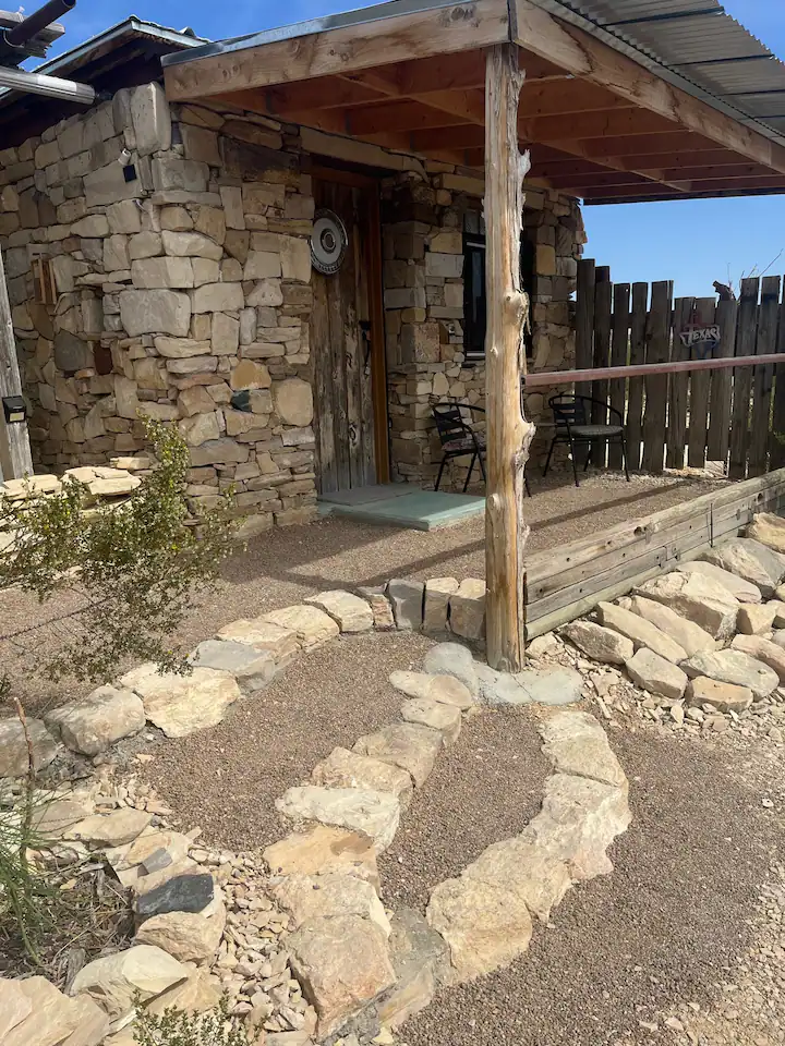 A stone walkway leading to the entrance of a house.